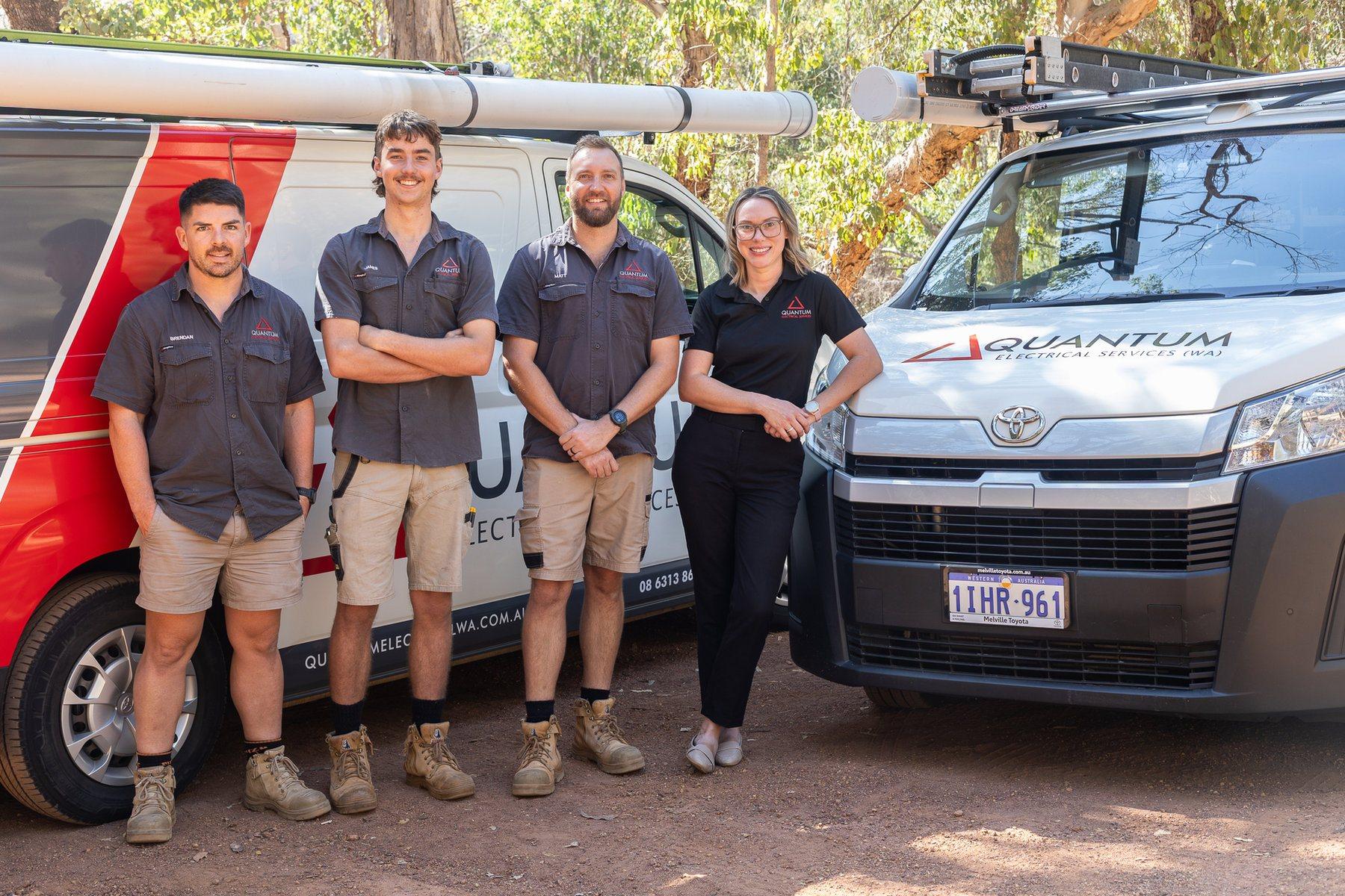 The Quantum Electrical team standing beside their branded vans in the Perth Hills