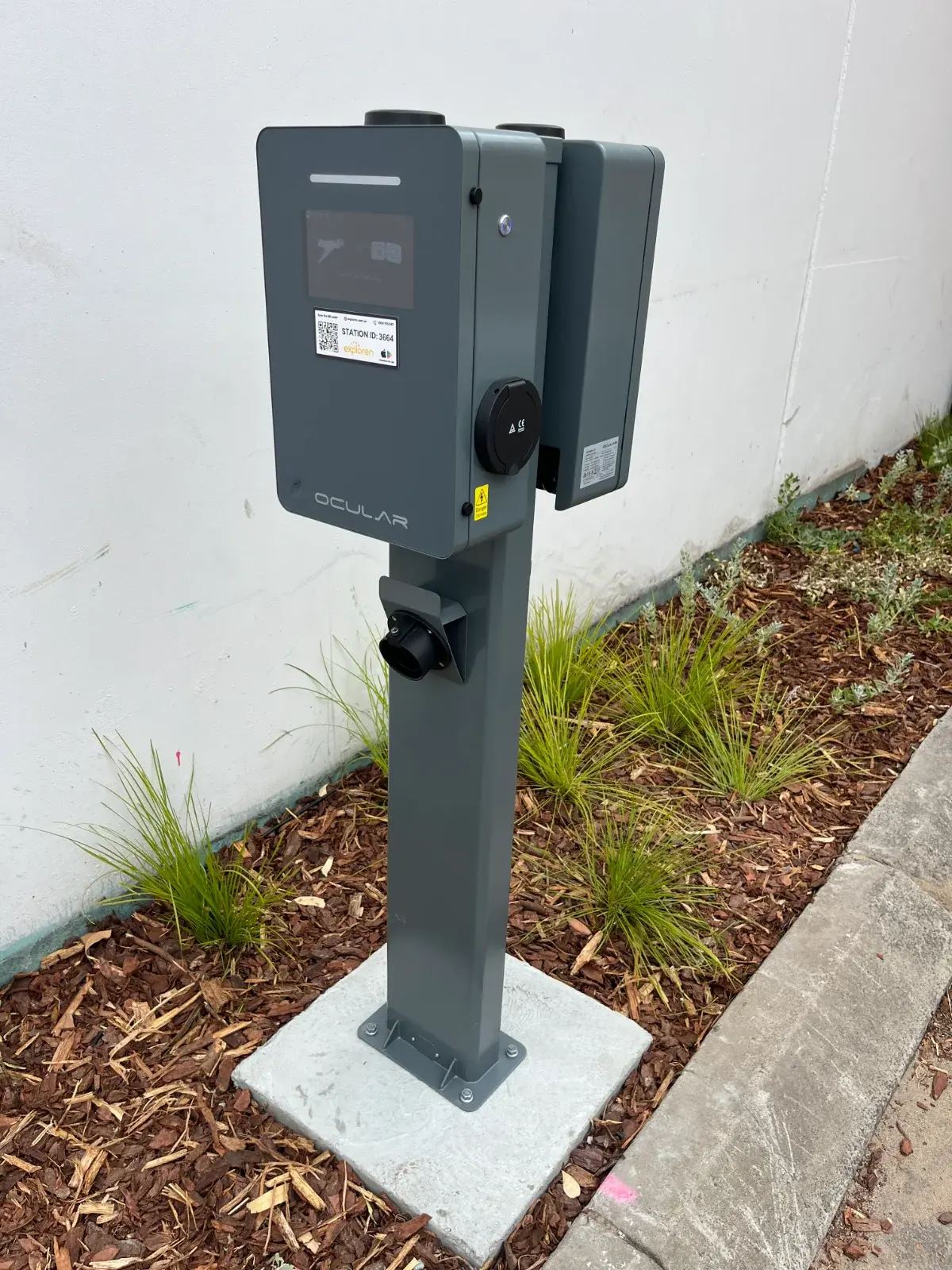 Wall-mounted home EV charger installed on a brick wall
