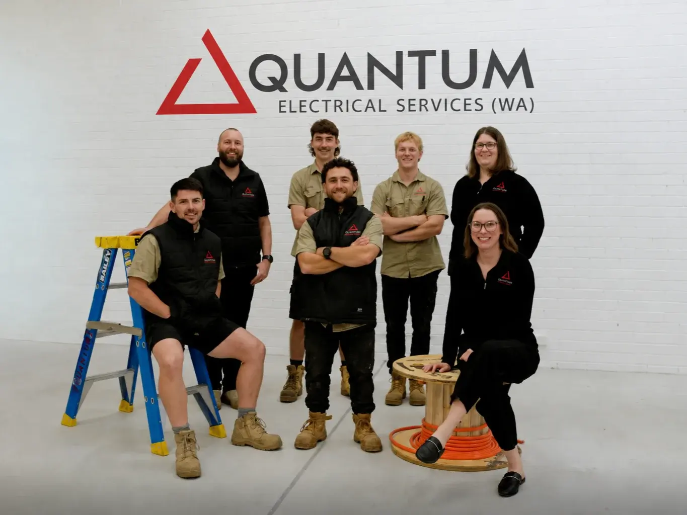 Quantum electricians standing in front of a branded Quantum van